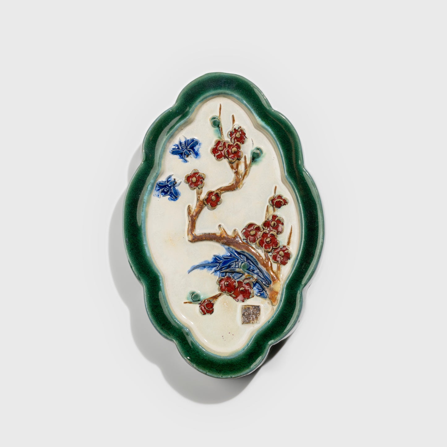 Shiwan handcrafted ceramic wall art depicting plum blossoms, traditional Chinese hanging vase with Cantonese glaze technique.