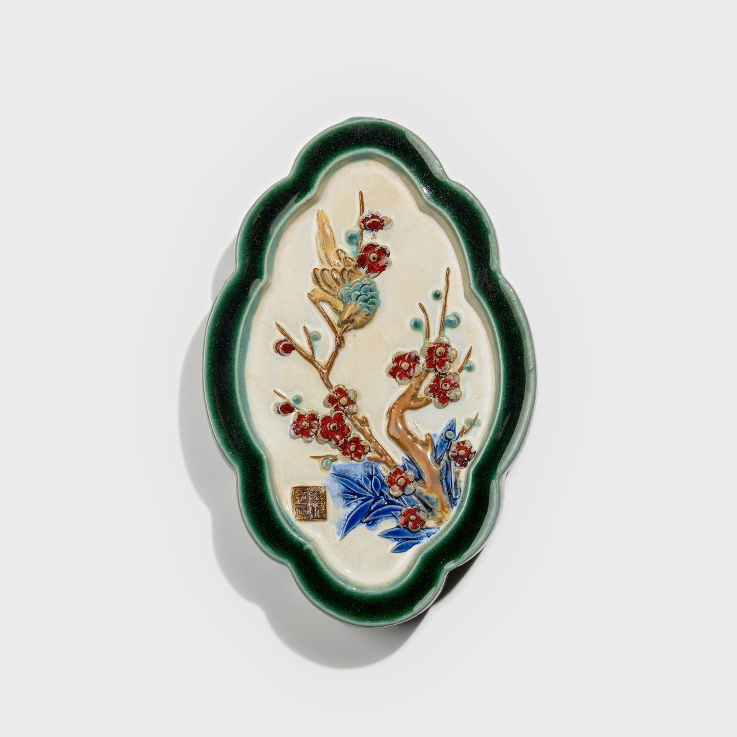Shiwan handcrafted ceramic wall art depicting plum blossoms, traditional Chinese hanging vase with Cantonese glaze technique.